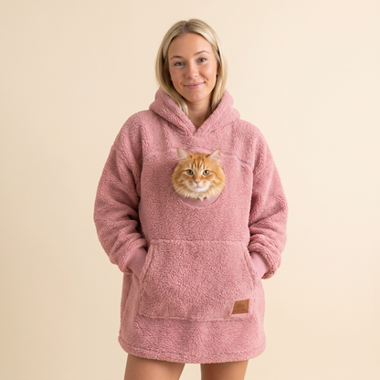 Woman wearing the pink Pawket hoodie with an orange cat in the chest pocket